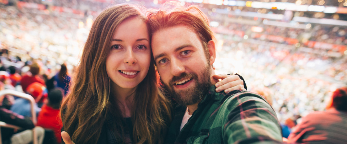 Couple at a sporting event taking a selfie