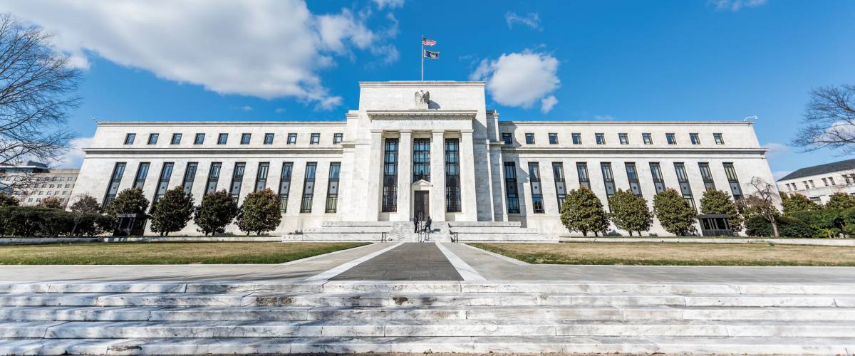 Washington DC, USA - March 9, 2018: Federal Reserve bank entrance wide angle architecture building wall security guard doors, path, american flags, blue sky