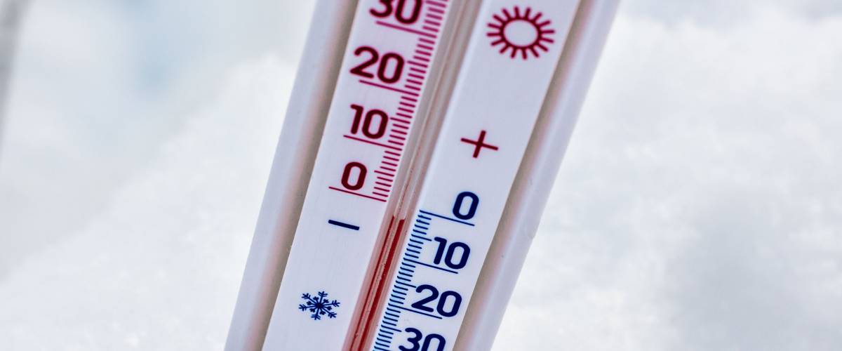 The thermometer in the snow shows 3 degrees below zero. Winter temperature