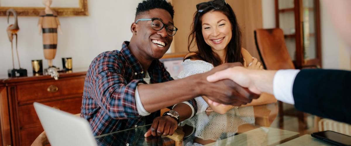 happy couple consulting with lawyer or real estate agent