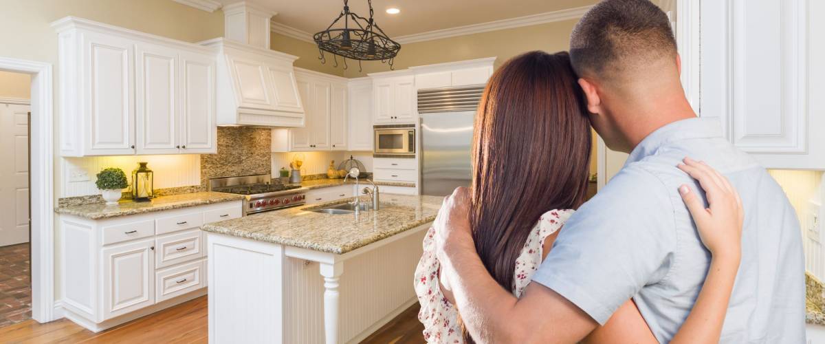 Young couple looking at beautifully renovated kitchen.
