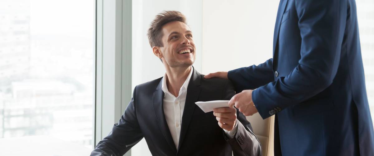 Employee receiving envelope of bonus cash from employer