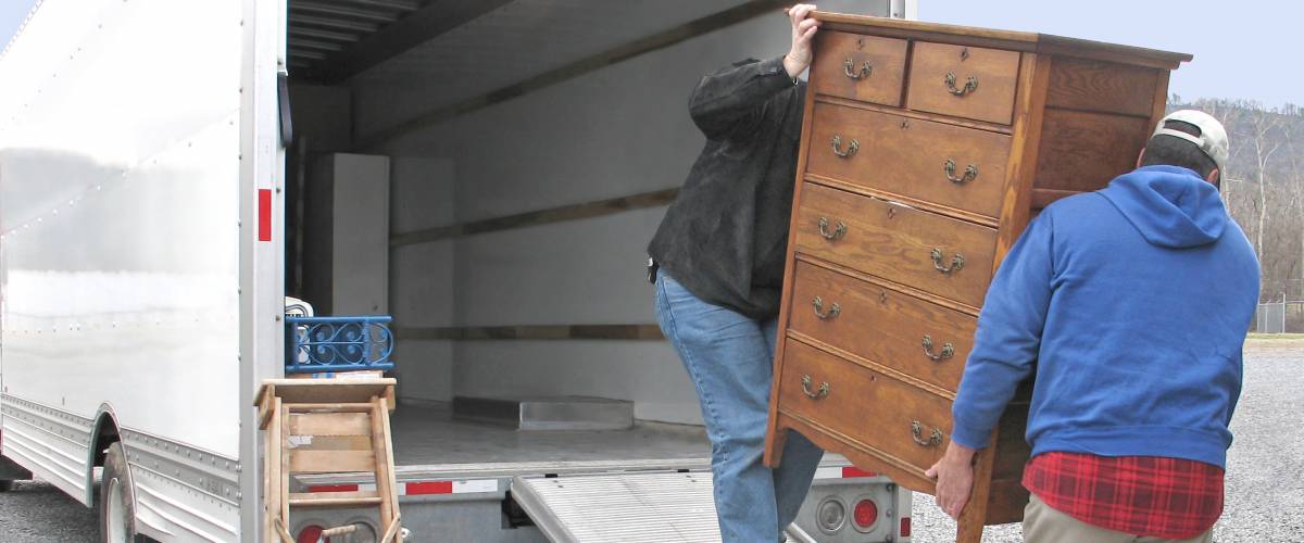 Men loading a dresser onto a moving van