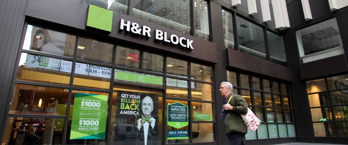 Man walking past H&R Block tax preparation office