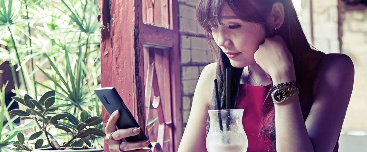 Woman waiting and checking her account to see if a transfer has cleared