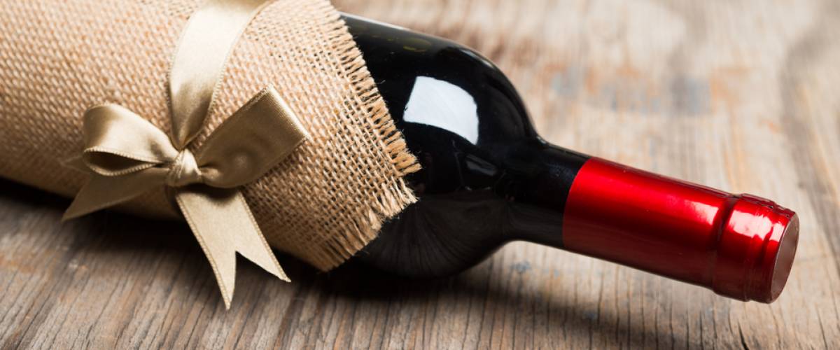 Red wine bottle wrapped with a bow