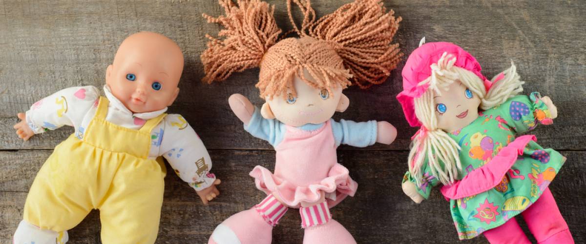 Toy dolls laying on wooden background
