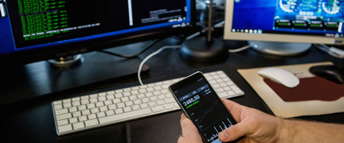 Man holding a phone with a bitcoin exchange rate