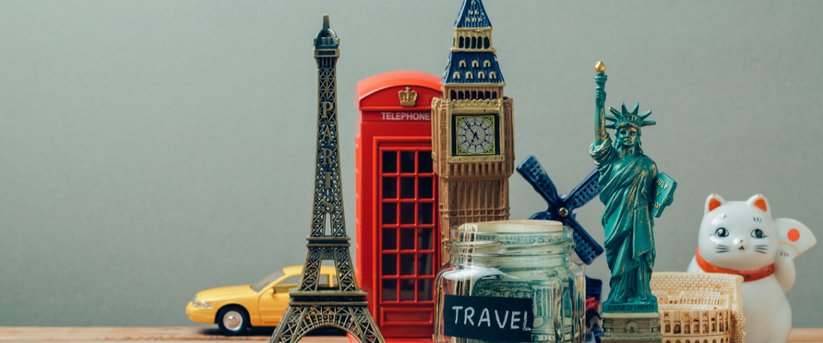Travel and tourism concept with souvenirs from around the world. Planning summer vacation, money budget trip concept. Saving money for vacation.