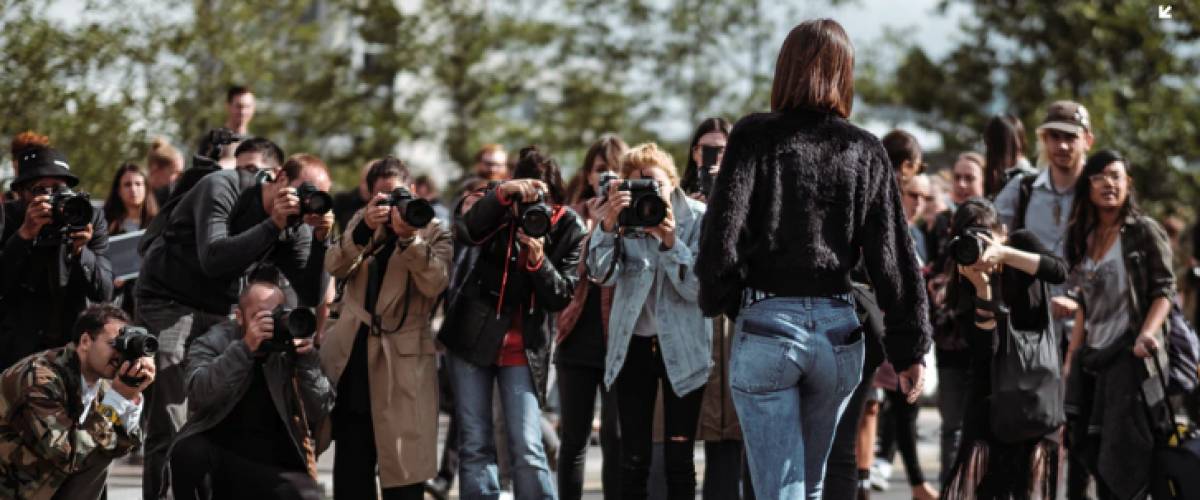Woman getting her photo taken by a group of people
