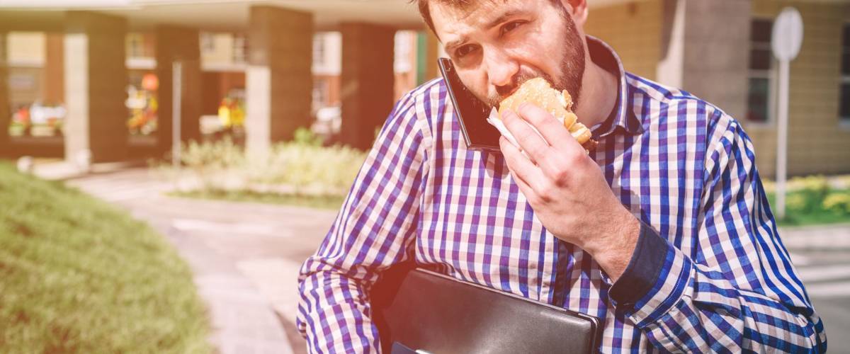 A businessman in a hurry, he does not have time, he is going to eat on the go.