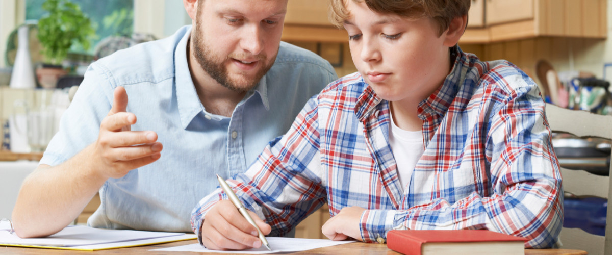 Male home tutor helping boy student with studies