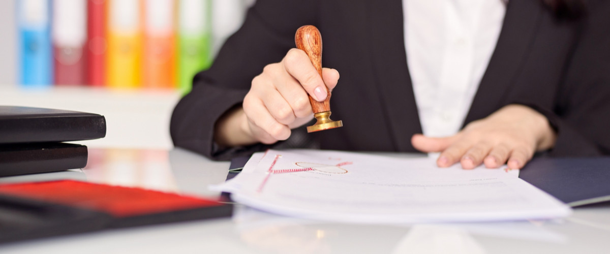 Close up on woman's notary public hand stamping the document