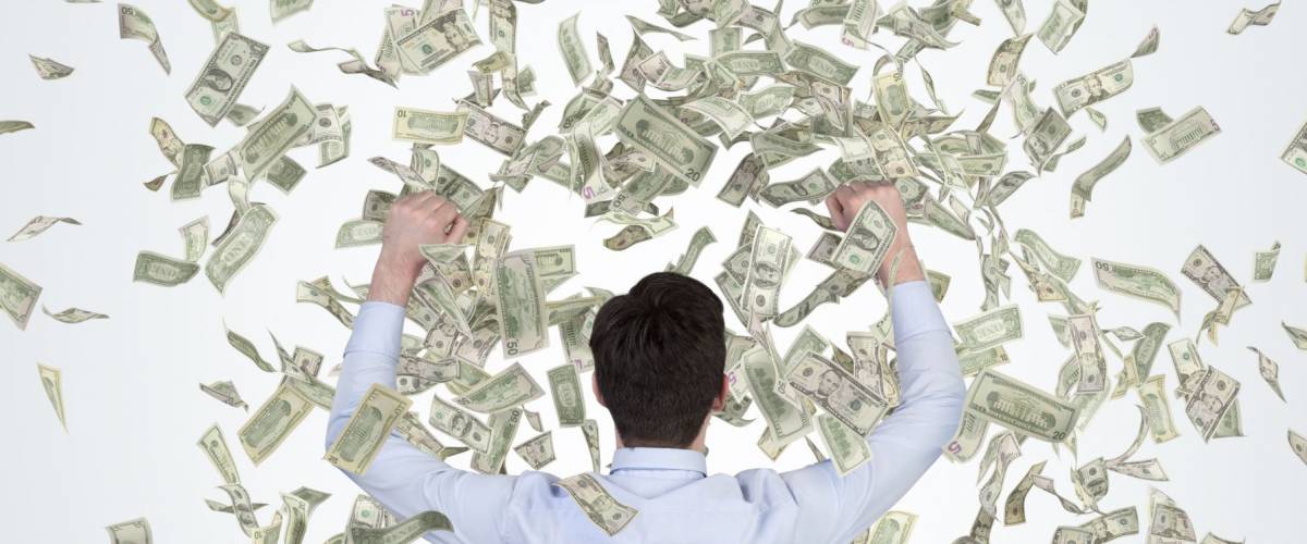 Businessman is happy about money rain as a metaphor of a successful job performance and enormous bonus payment