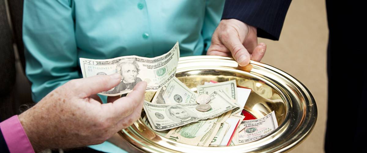 Church members putting money in the collection plate.