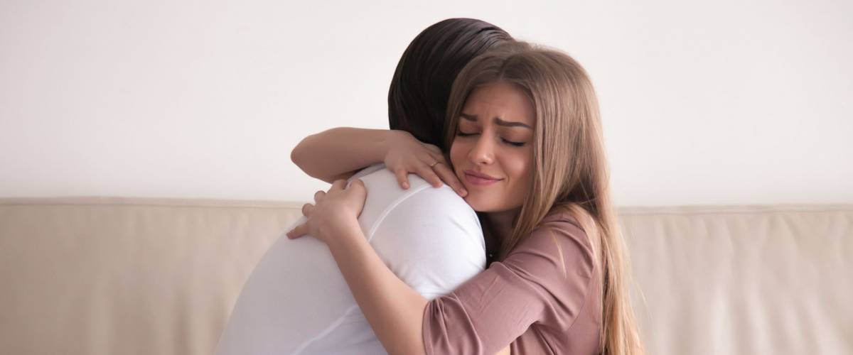Portrait of emotional young couple hugging each other