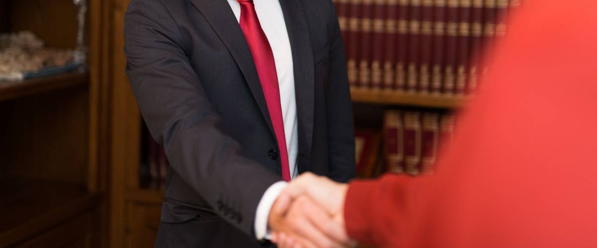 Portrait of a smiling businessman giving an handshake to a customer