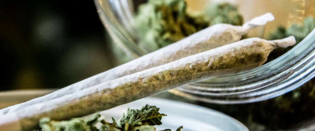 Marijuana Joints Next to a Jar