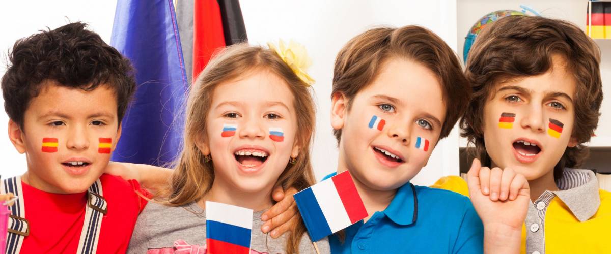 Kids with flags on cheeks singing at the classroom