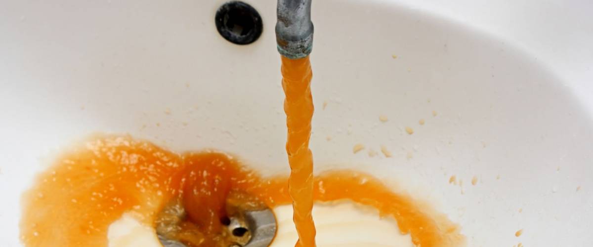 Color photography of a rusty water what run from a faucet