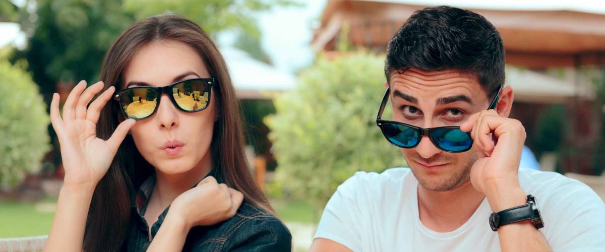 Surprised Couple Wearing Matching Trendy Fashion Sunglasses. Funny girlfriend and boyfriend at restaurant date