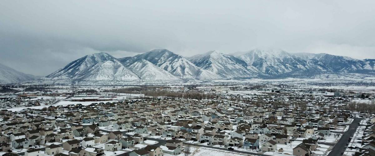 Aerial drone images of Provo Utah, Utah Valley. Snow covered neighborhoods with snow capped mountains in the back ground
