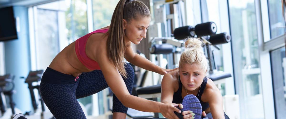 woman exercise and working out with fitness personal trainer in gym