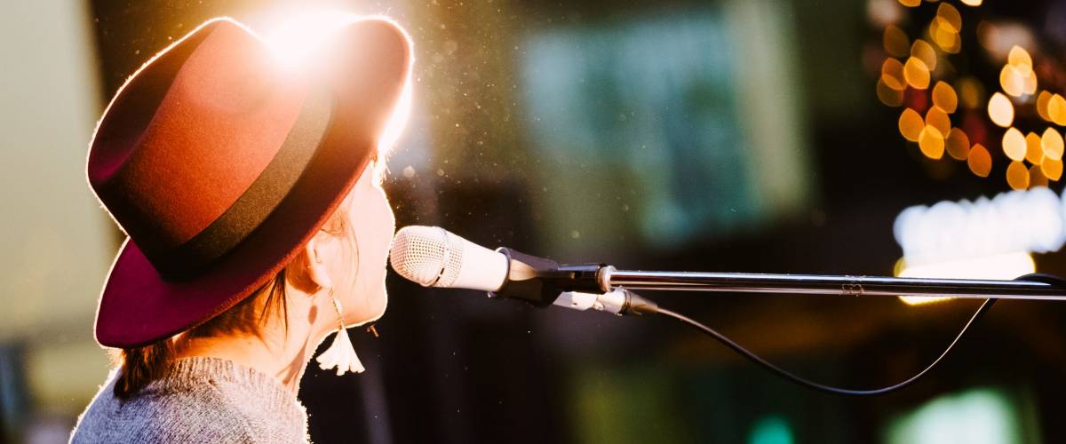 Female singer, performing her vocal sound. With lens flare and spotlight.
