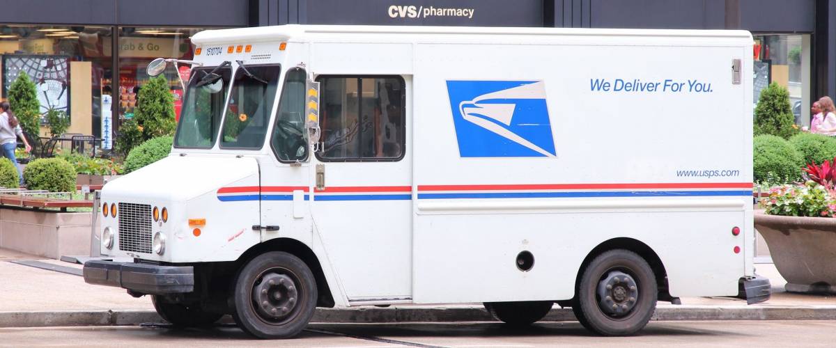 CHICAGO - JUNE 26: People walk past US Postal Service truck on June 26, 2013 in Chicago. USPS is the operator of the largest civilian vehicle fleet in the world.