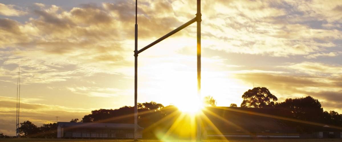 Goal posts for football, rugby union or league on field at sunset