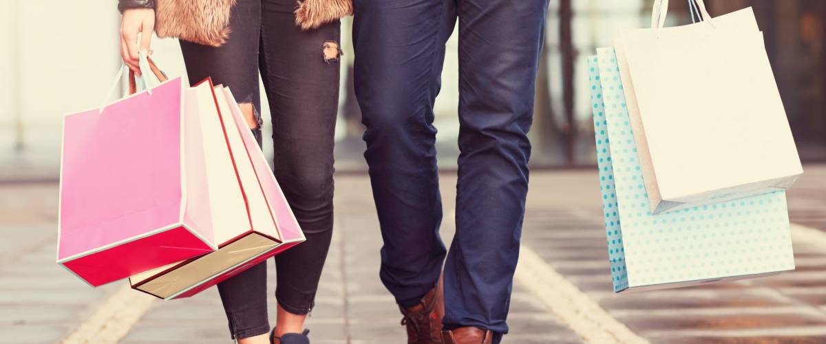 Midsection of couple with shopping bags in city