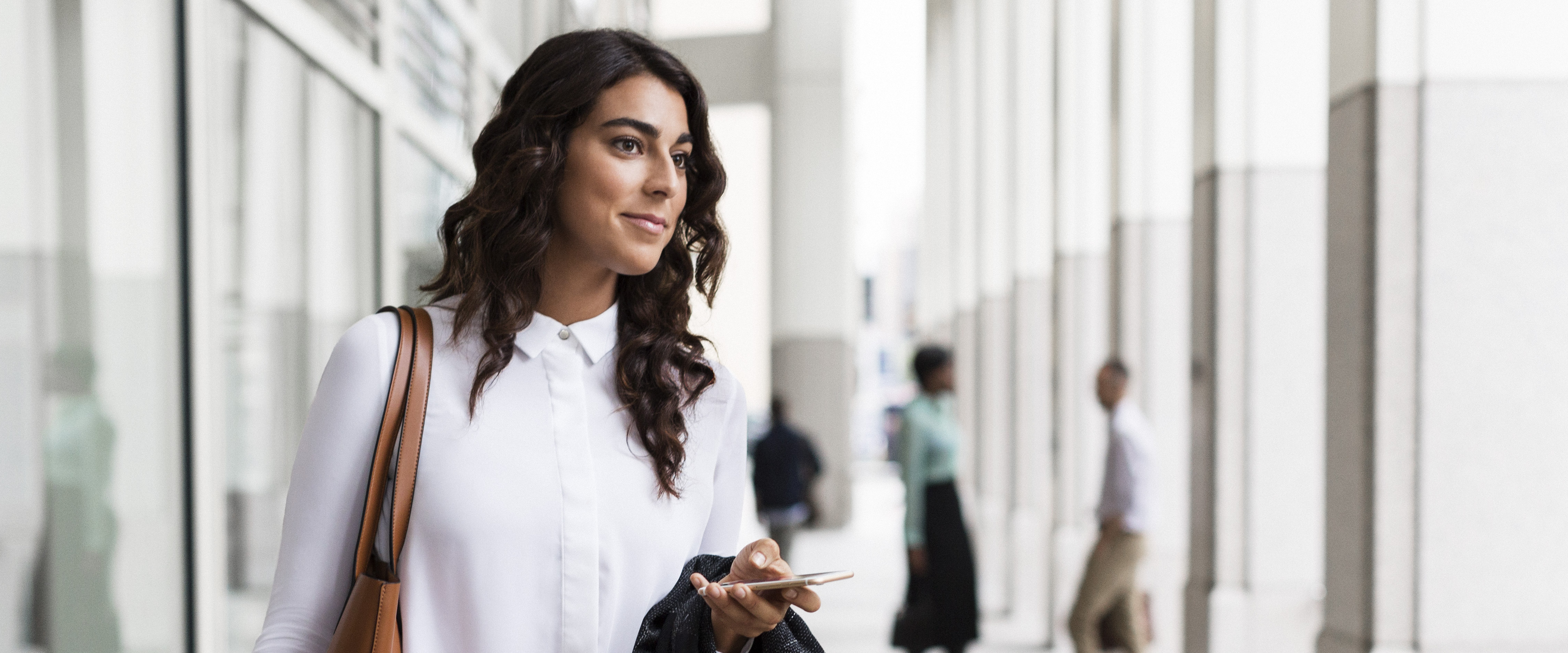 Young woman calling an Uber on her mobile phone