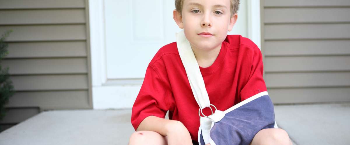 Boy with broken arm in a sling and cast