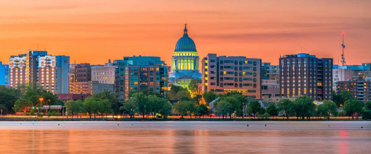 Madison, Wisconsin, USA downtown skyline at dusk on Lake Monona.