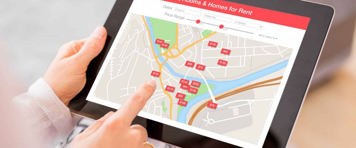 Person looking for places to stay on digital tablet app
