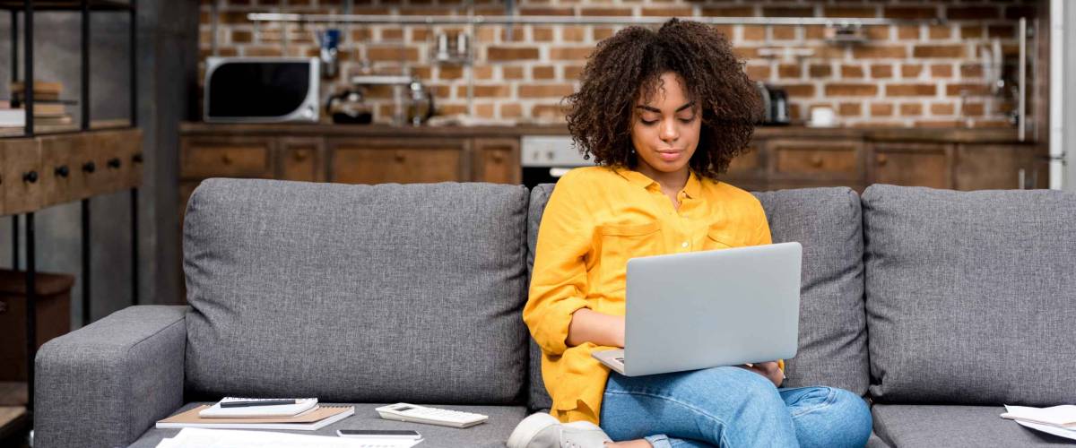 attractive young woman working working with laptop on couch