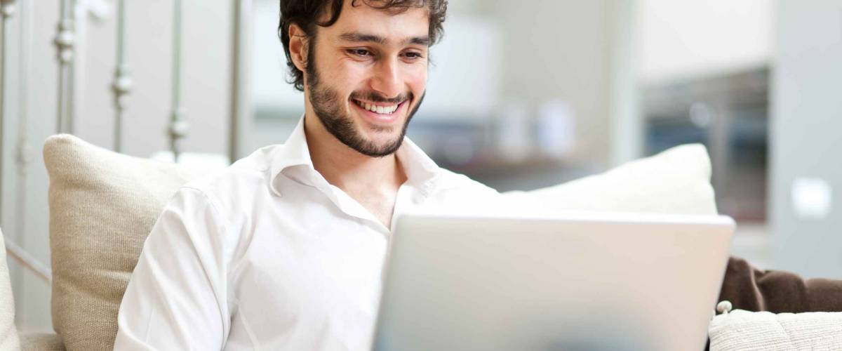 Young man relaxing on the sofa with a laptop