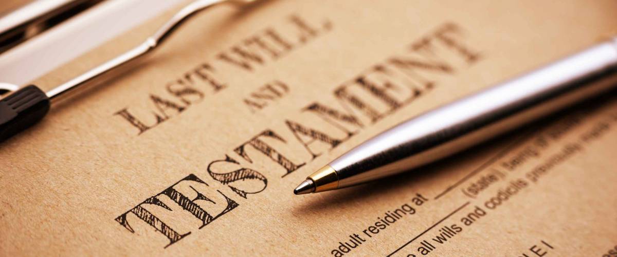 Blue ballpoint pen and a last will and testament on a clip board