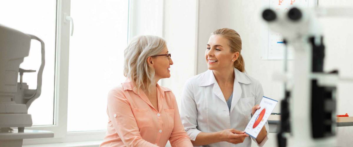 Important conversation. Beaming long-haired woman having appointment with older patient and discussing her issues