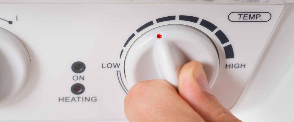 Close-up Of Person Hands Turning The Knob Of Electric Boiler