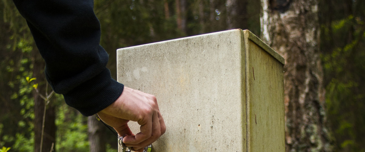 Man opens a metal box in the woods