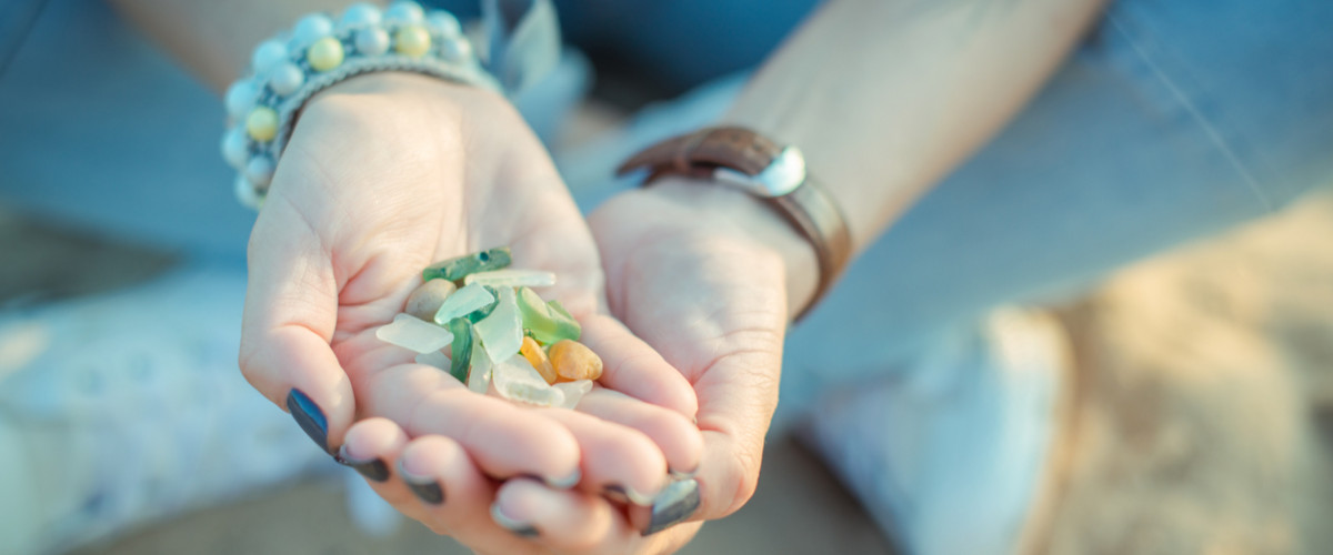 Sea glass pieces in the hands of a young woman